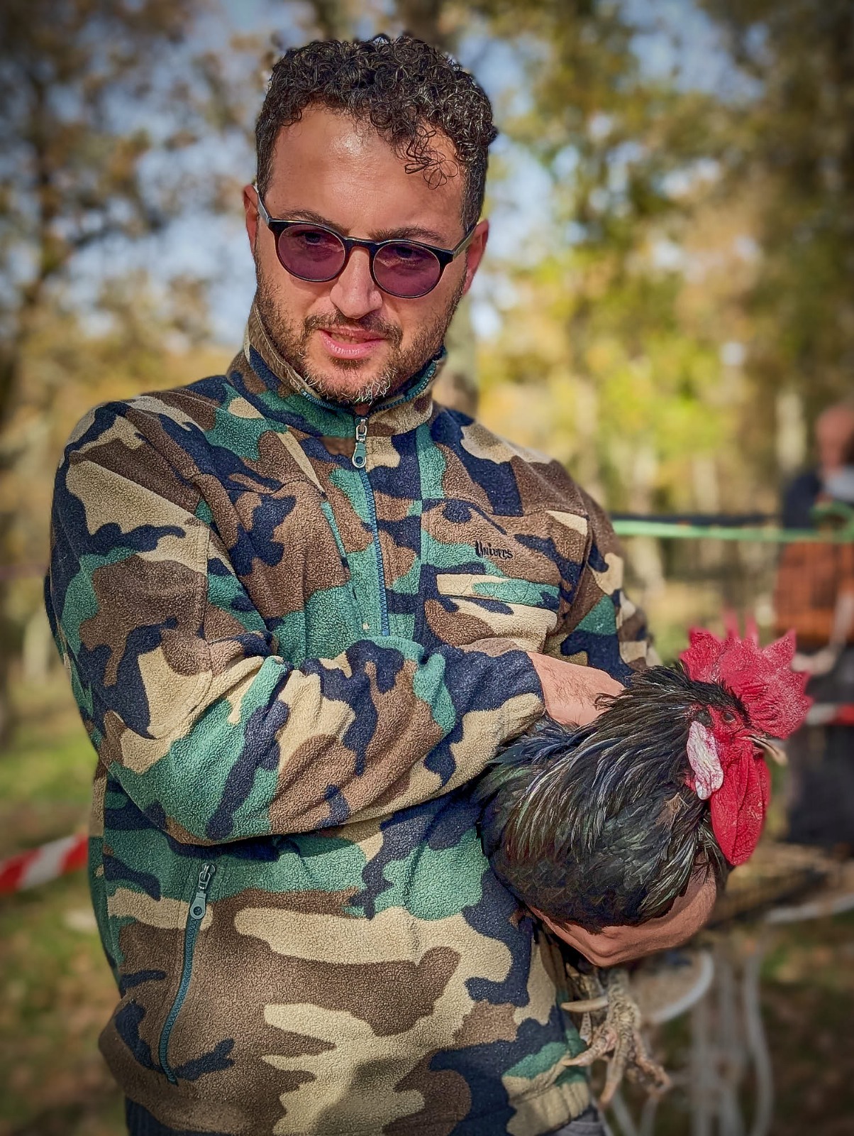 Un partecipante tiene in braccio un gallo durante una pausa al cantiere.