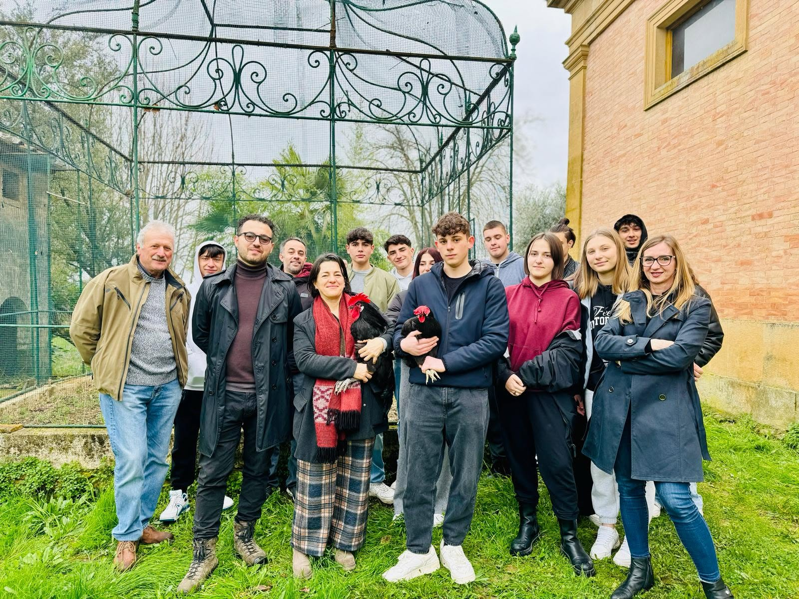 Un gruppo di studenti e partecipanti al progetto Gallo Nero con due esemplari all’Istituto Ricasoli di Siena.